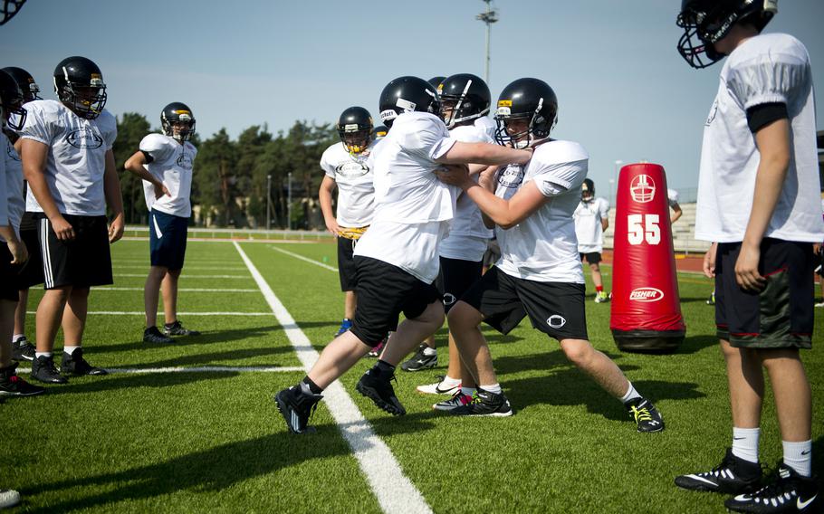 Stuttgart players run defensive drills during football camp at Vogelweh, Germany, on Tuesday, Aug. 15, 2017.