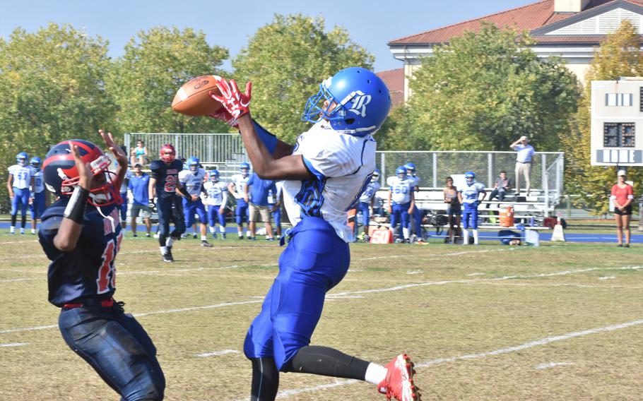 Rota's Josh Holmes tries to bring the ball in while Aviano's Donavin Robinson tries to distract him. Holmes couldn't make the catch in Rota's 33-30 loss to the Saints on Saturday.