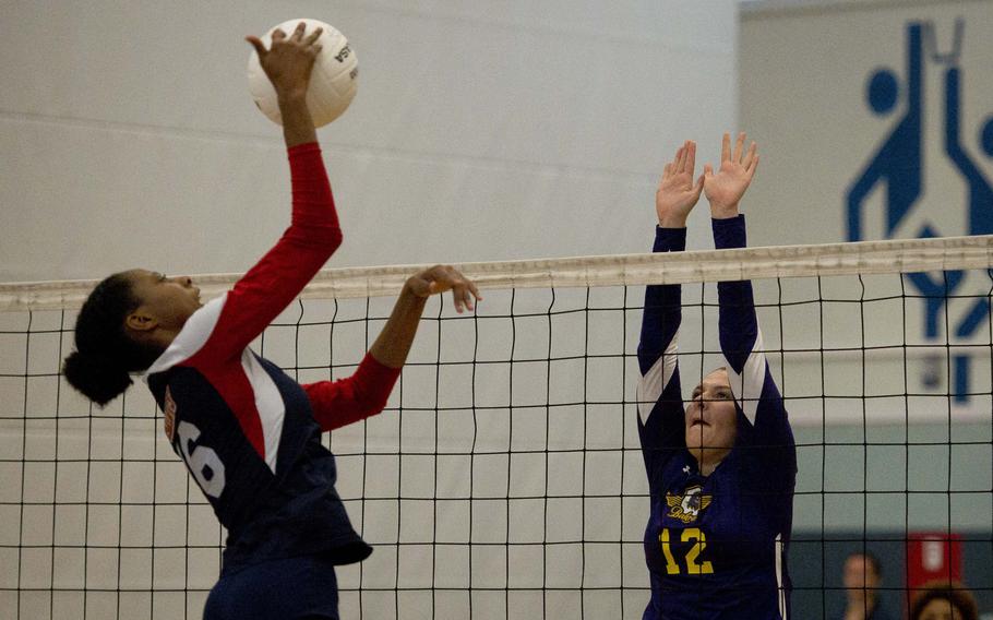 Bahrain's Christina Carpenter-Lopez, right, jumps to block a spike by Aviano's Layla Thomas during a DODEA-Europe championship tournament match at Vogelweh, Germany, on Thursday, Nov. 2, 2017.

