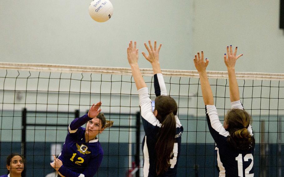 Bahrain's Christina Carpenter-Lopez returns the ball as Black Forest Academy's Brianna Maier, right, and Kennedy Wilbanks jump to block during the DODEA-Europe semifinals at Vogelweh, Germany, on Friday, Nov. 3, 2017.