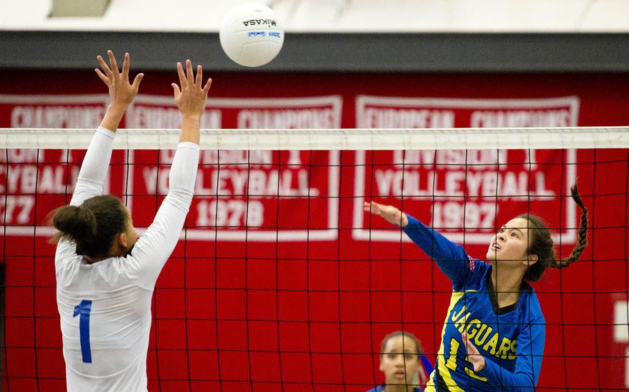 Sigonella's Kristiana Wyrick, right, hits the ball over Brussels' Evin Harper during the DODEA-Europe volleyball championships at Vogelweh, Germany, on Friday, Nov. 3, 2017.
