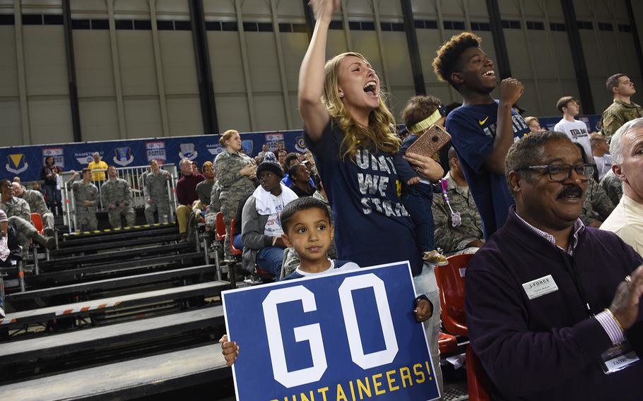 Dijana Mackey, center, cheers on the West Virginia Mountaineers with Khalil Mackey (holding sign) and Cross Workcuff on Friday, Nov. 10, 2017, at the Armed Forces Classic at Ramstein Air Base, Germany.


