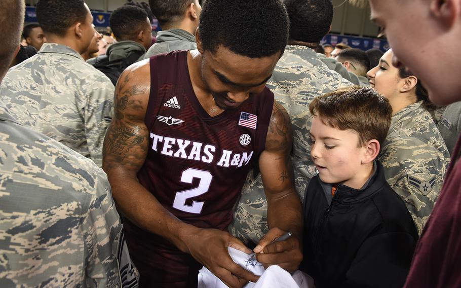 Texas A&M's TJ Stark signs a T-shirt for Blake Clonts on Friday, Nov. 10, 2017, following the Aggies' defeat of West Virginia, 88-65, at the Armed Forces Classic at Ramstein Air Base, Germany.


