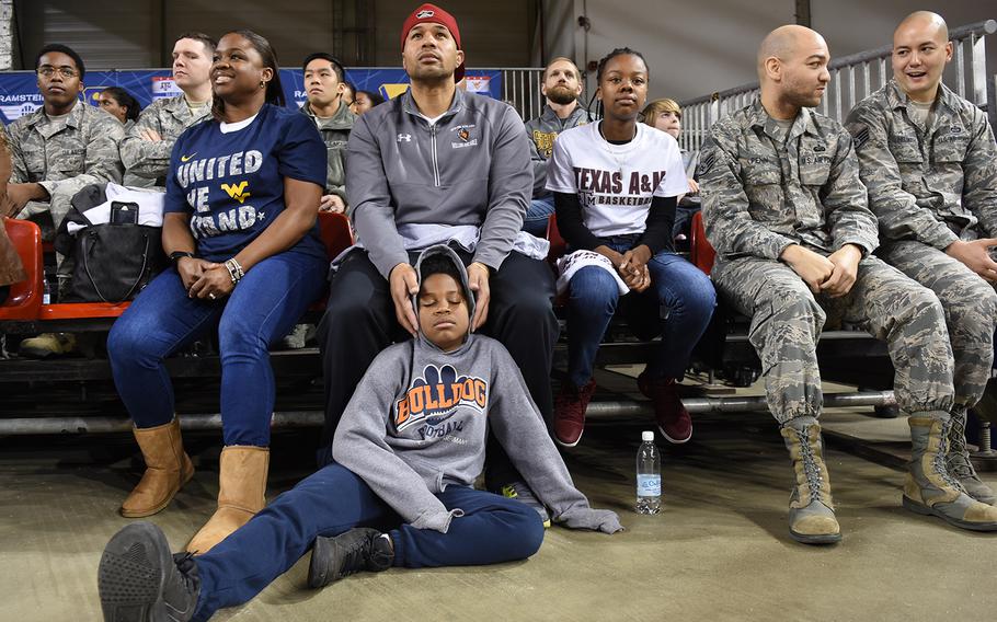 Tareavion Mageo, 10, catches some shuteye while leaning against his dad, Sgt. 1st Class Jerome Mageo. His mother, Karen Mageo, sits on his left. The family was cheering for West Virginia and got standby tickets to the game.

