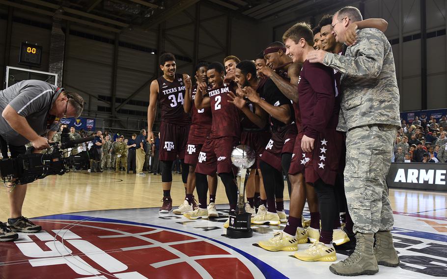 Brig. Gen. Richard Moore Jr., the 86th Airlift Wing commander at Ramstein Air Base, Germany, and the Texas A&M basketball team gather around the trophy the Aggies won for winning the Armed Forces Classic.

