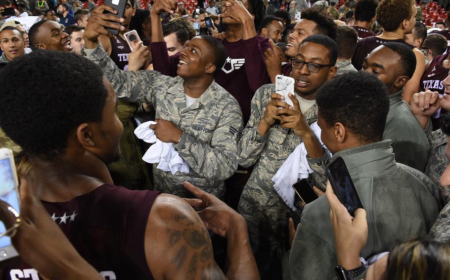 Airmen and others swarm around Texas A&M players, taking selfies and videos after the Aggies win over West Virginia in the Armed Forces Classic on Friday, Nov. 10, 2017, at Ramstein Air Base, Germany.

