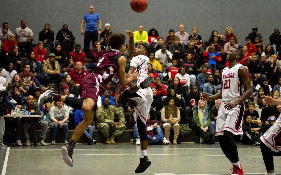 Kaiserslautern's Ervin Johnson goes for a shot as Vilseck's Devin Gamble, left, tries to block and Marlon Robbins watches at Vogelweh, Germany, on Friday, Dec. 1, 2017. Kaiserslautern won the game 83-44.