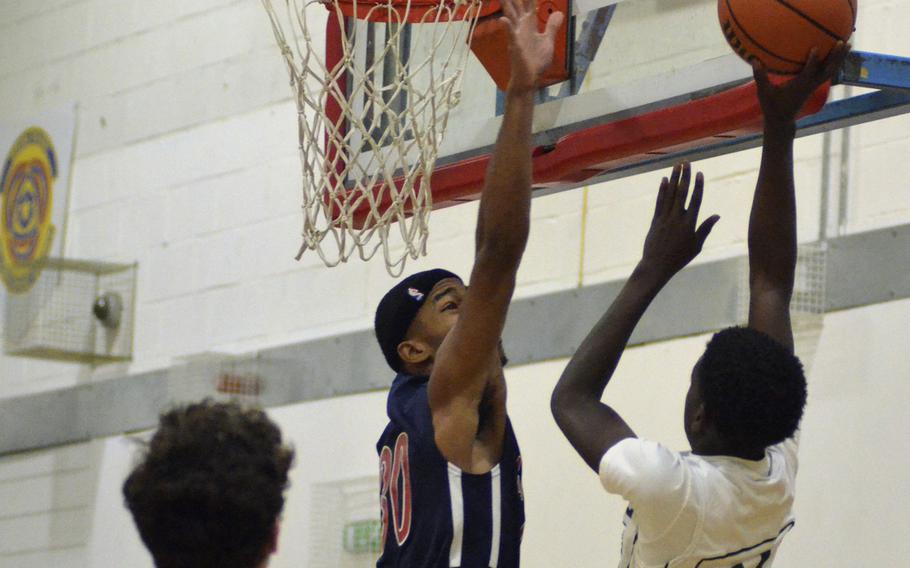 Naples' Tye Thompson shoots against Lakenheath’s DeShawn Wilkerson during a varsity basketball game at RAF Lakenheath, England, Saturday, December 2, 2017. Thompson had 12 points in the loss versus the Lancers. 