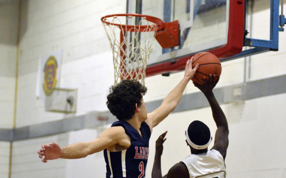 Lakenheath’s Kobe Cox blocks a shot by Anthony Newtons during a varsity basketball game against Naples at RAF Lakenheath, England, Saturday, December 2, 2017. Cox led his team to victory with 20 points. 