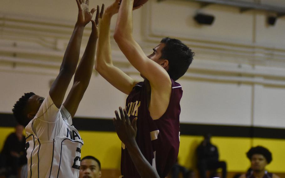 Naples' Tyrone Haynes tries to defend against Vilseck's Marshall Bender in the Falcons' 59-52 victory Friday over the Wildcats.