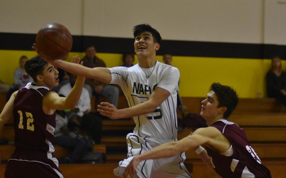 Naples' Omar Lopez eludes Vilseck defenders Isaiah Hernandez, left, and Tim Simmons in the Falcons' 59-52 win over the Wildcats on Friday.