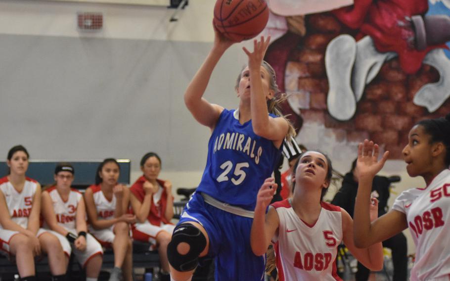 Rota's Sam Miller puts up a shot over American Overseas School of Rome's Amaya Vaquerizo and Marie Pascaline in the Admirals' 16-7 victory over the Falcons on Friday at Aviano Air Base, Italy
