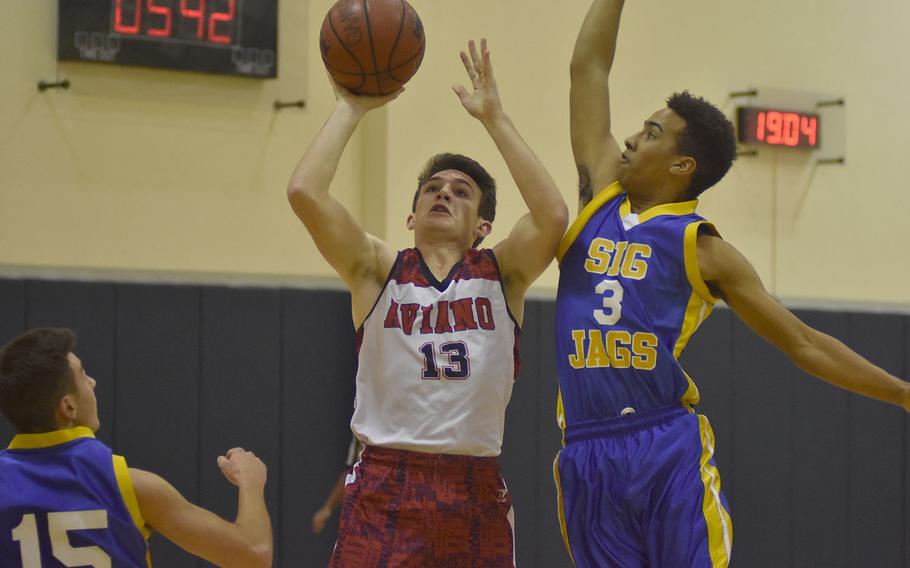 Aviano's Mason Shine puts up a shot, but Sigonella's Sean Solano rejects it in the first half Friday night. Shine's team came out on top, though, 43-38.