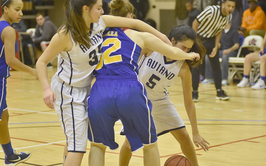 In an often physical game, Aviano's Alyssa Resch, from left, Sigonella's Kylee Fall and Aviano's Elizabeth Lopez fight for the ball in the Jaguars' 40-33 victory Friday night.
