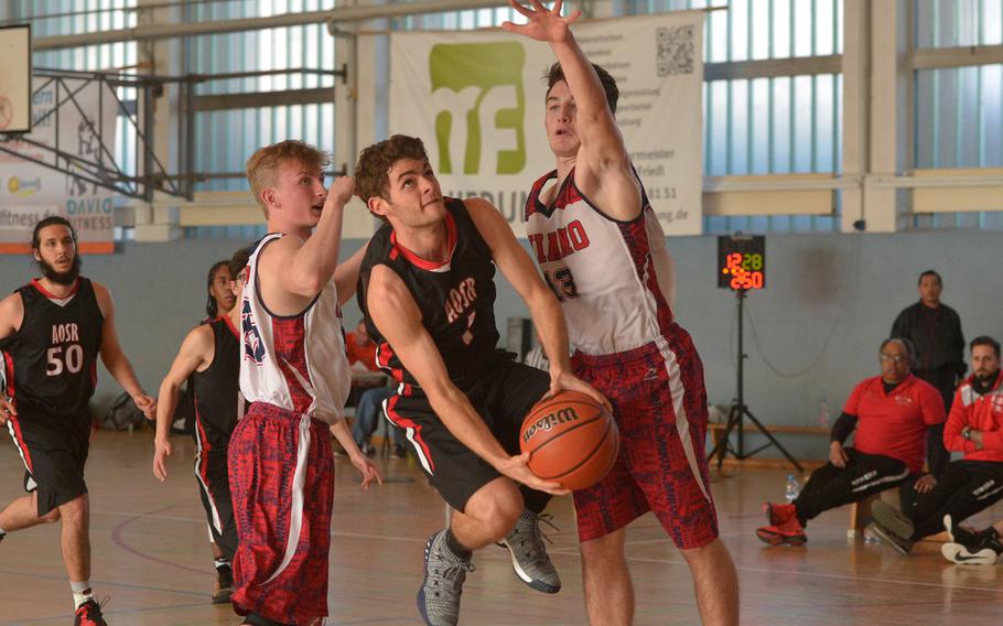 AOSR's Brando Monetti takes and off-balance underhand shot against Aviano's Matthew Robertson, left, and Mason Shine in a Division II game at the DODEA-Europe basketball championships in Wiesbaden, Germany, Wednesday, Feb. 21, 2018. Aviano won 39-23.