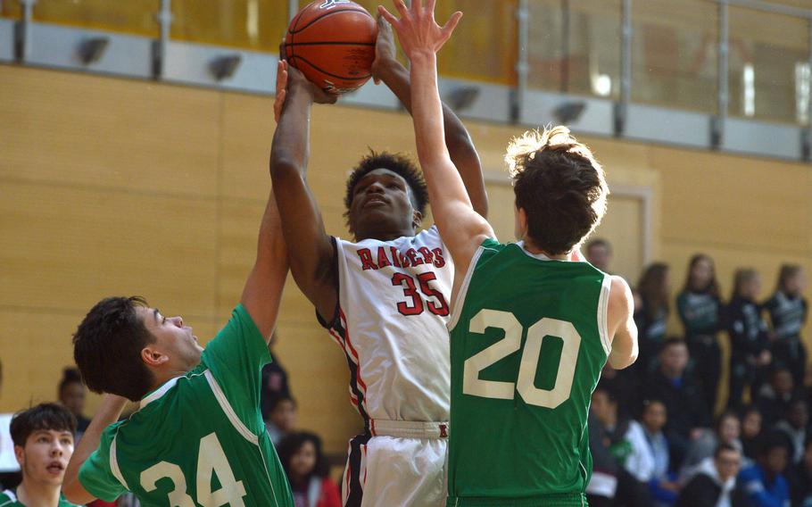 Kaiserslautern's Tre Dotson takes a shot against SHAPE's Marios Giannopoulos, left, and George Valchakis in a Division I game at the DODEA-Europe basketball championships in Wiesbaden, Germany, Wednesday, Feb. 21, 2018. Kaiserslautern won 62-23.