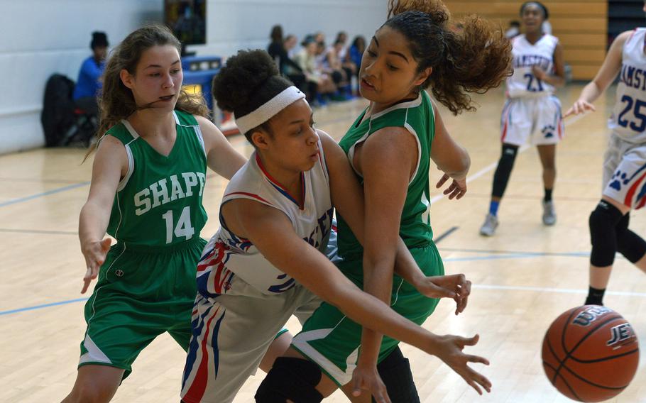 Ramstein's Shemilia Johnson passes the ball off to a teammate against the defense of SHAPE's Maria Rebrean, left, and Leilynn Arrington in a Division I game at the DODEA-Europe basketball championships in Wiesbaden, Germany, Wednesday, Feb. 21, 2018. Ramstein beat SHAPE 36-10.

