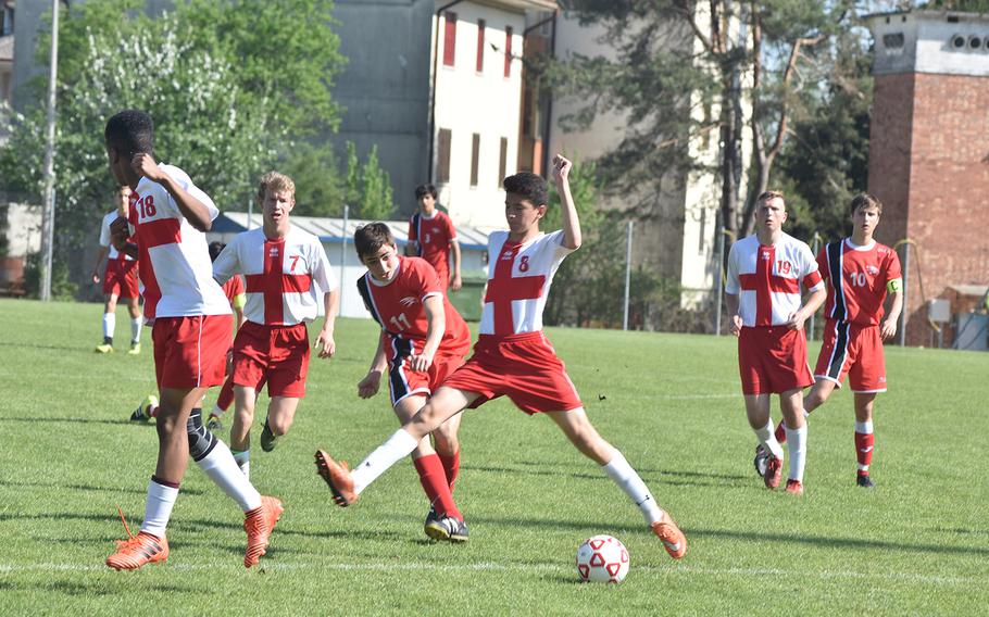 American Overseas School of Rome's Tomasso Anticoli kicks the ball through the outstretched legs of Aviano's Zachary Villa on Saturday, April 21, 2018.