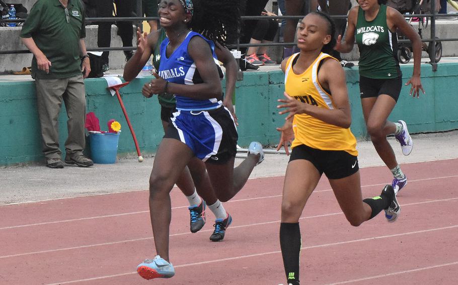 Vicenza's Kaiah Hicks edges past Rota's Erica Tobin in the final stretch of the 200 during a track meet at Naples Middle High School in Gricignano, Italy. 