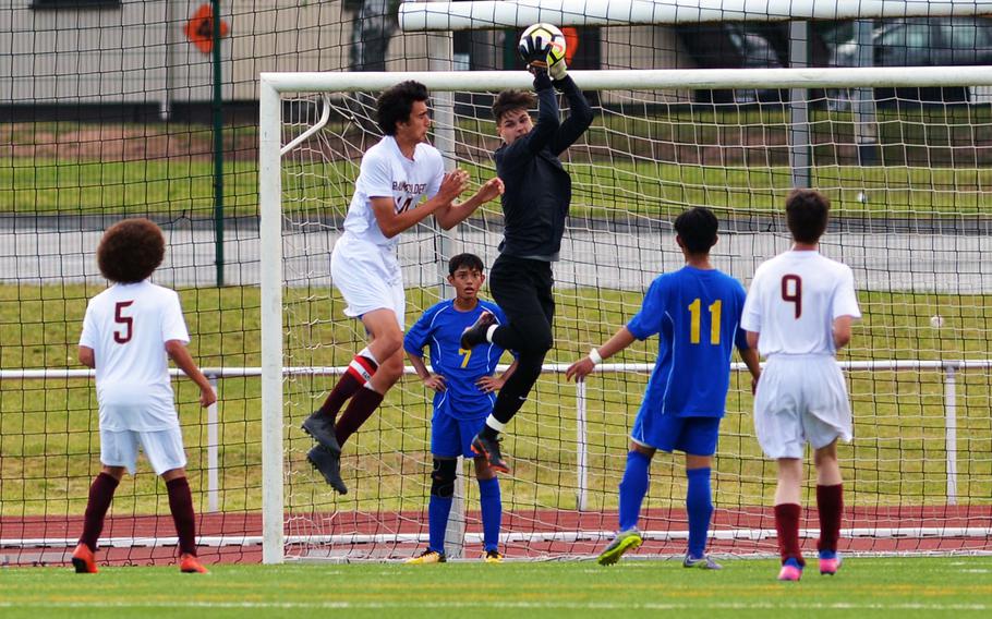 Ansbach keeper Nick Benson pulls in the ball against Baumholder's Brandon Perales in a Division III game at the DODEA-Europe soccer finals in Kaiserslautern, Germany, Monday, May 21, 2018. Ansbach won 7-0.





