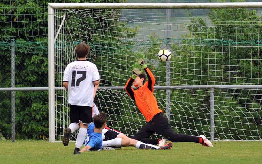 Marymount's Alexander Herne, blue jersey, scores his team's fourth goal as AOSR's Arnaldo Di Biase watches in a Division II semifinal at the DODEA-Europe soccer finals in Reichenbach, Germany, Wednesday, May 23, 2018. Marymount won 4-2 to advance to Thursday's final.