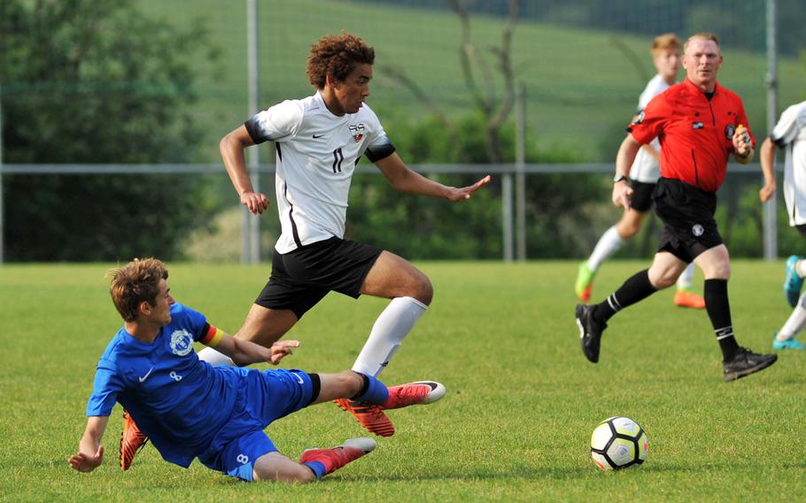 Stuttgart's Gustavus de Andrade avoids the tackle by Ramstein's Gregory McMillan in a Division I semifinal at the DODEA-Europe soccer finals in Reichenbach, Germany, Wednesday, May 23, 2018. Stuttgart beat Ramstein 1-0 to advance to Thursday's division final against Kaiserslautern.