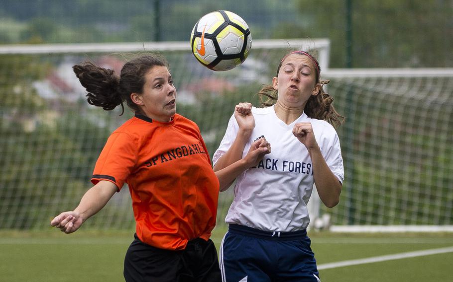 Spangdhalem's Summer Flores, left, and Black Forest Academy's Rebecca Losey jump for the ball during the DODEA-Europe soccer championships in Reichenbach, Germany, on Wednesday, May 23, 2018.
