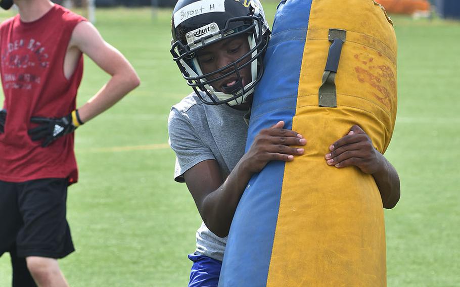 Vicenza senior Bryant Horton carries a practice dummy during a recent practice at Caserma Ederle in Italy.
