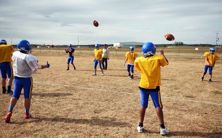 The Ansbach Cougars pass footballs during practice, Monday, August 27, 2018. 