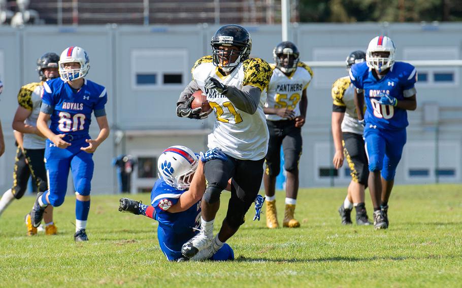 Gavin Abney tries to break a tackle to pick up a few extra yards during the Ramstein vs Stuttgart football game on Saturday, Sept. 15, 2018.  Ramstein won the game 41-19.