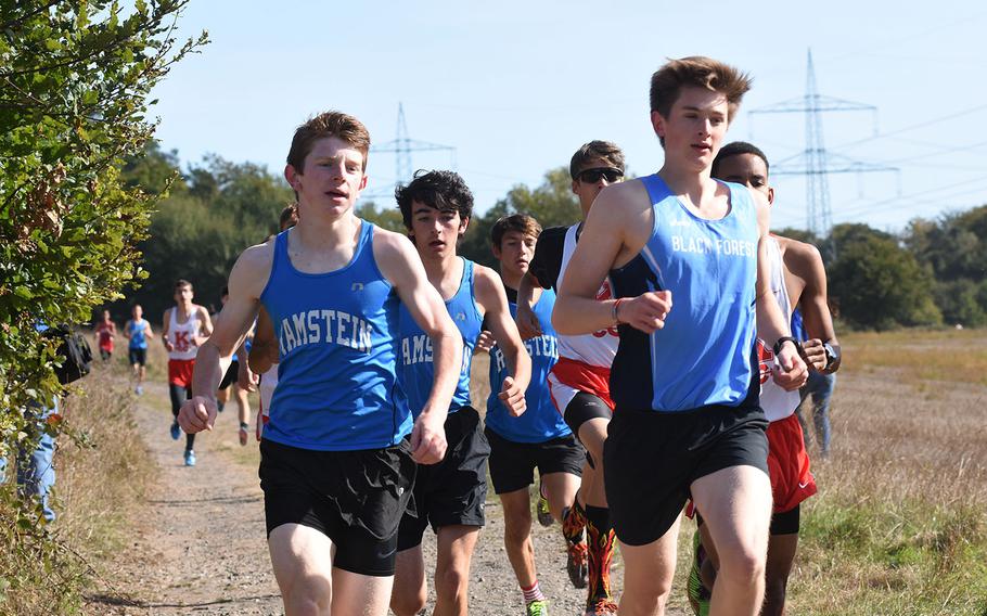 Ramstein's Denver Dalpias, left, and Dashiell Rogers run at the front of the pack with Black Forest Academy's Mac Roberts in the early stages of the Ramstein cross country meet on Saturday, Sept. 29, 2018, in Miesenbach, Germany.