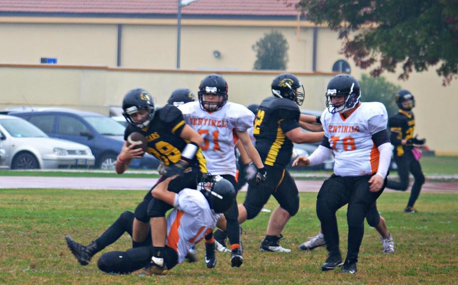 Tyler Keller, a defensive end with the Spangdahlem Sentinels, tackles Jesse Samsel, a quarterback with the Vicenza Cougars. Vicenza defeated Spangdahlem 39-3 in Saturday's rainy game.