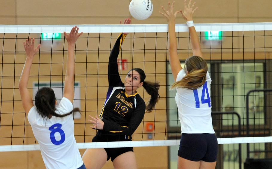 Bahrain's Christina Carpenter-Lopez hits the ball between Marymount's Alessandra Riviere, left, and Margherita Guerra in a Division II match at the DODEA-Europe volleyball finals in Kaiserslautern, Germany, Thursday, Nov. 1, 2018. Bahrain beat MMI 25-18, 25-27, 21-25.