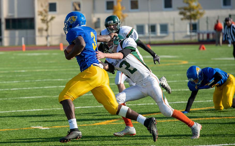 Ogden Andrew from Ansbach stiff arms a defensive player during the DODEA-Europe Division III football championship game between the Ansbach Cougars and AFNORTH Lions, Saturday, Nov. 3, 2018. 