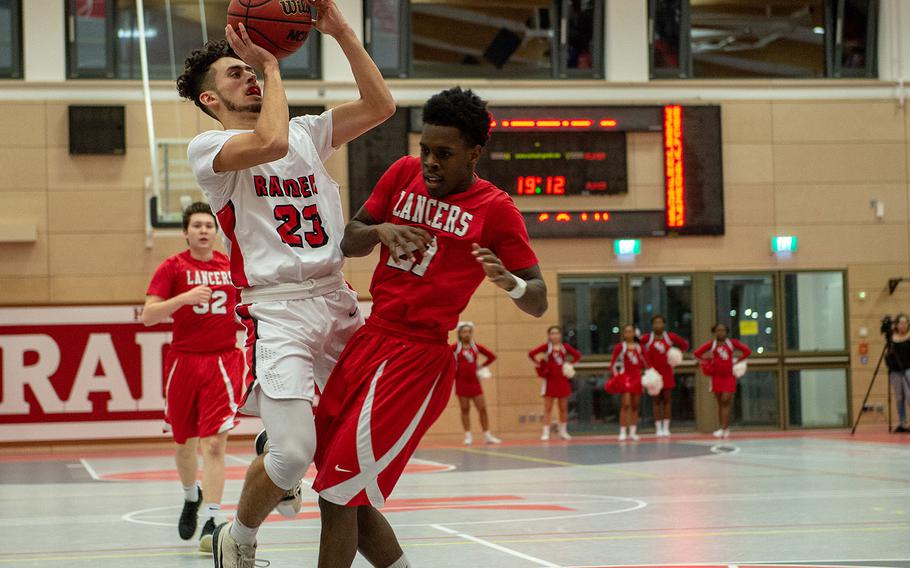 Eric Santiago takes a shot over Kyrie Sloan during the Kaiserslautern vs Lakenheath boys basketball game at Kaiserslautern High School, Friday, Jan. 18, 2019.  Kaiserslautern won the game 62-59.