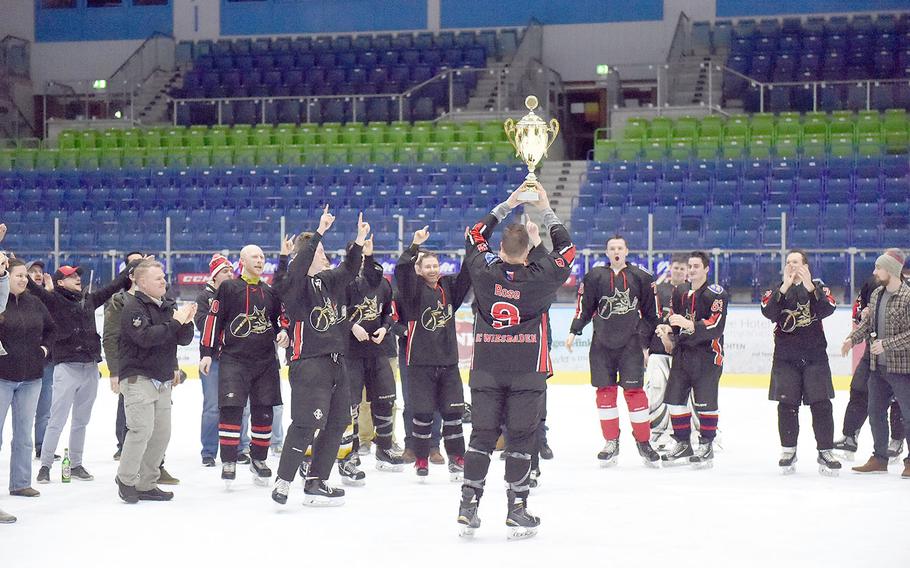 Wiesbaden Vikings' coach Luke Rose raises the first place trophy for the Alpine Classic Hockey Tournament up after winning their final game, at Garmisch, Germany, Saturday, Feb. 16, 2019. 
