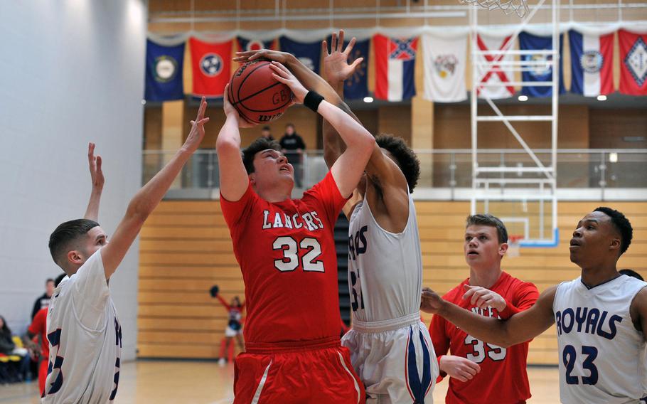 Lakenheath's Daniel Uelmen tries to get a shot off against Ramstein's Luis Santiago, left, and Jason Jones Jr. in a Division I game at the DODEA-Europe basketball finals. Ramstein won 49-37. Watching the action are Adam Woolley and Naser Eaves, right.