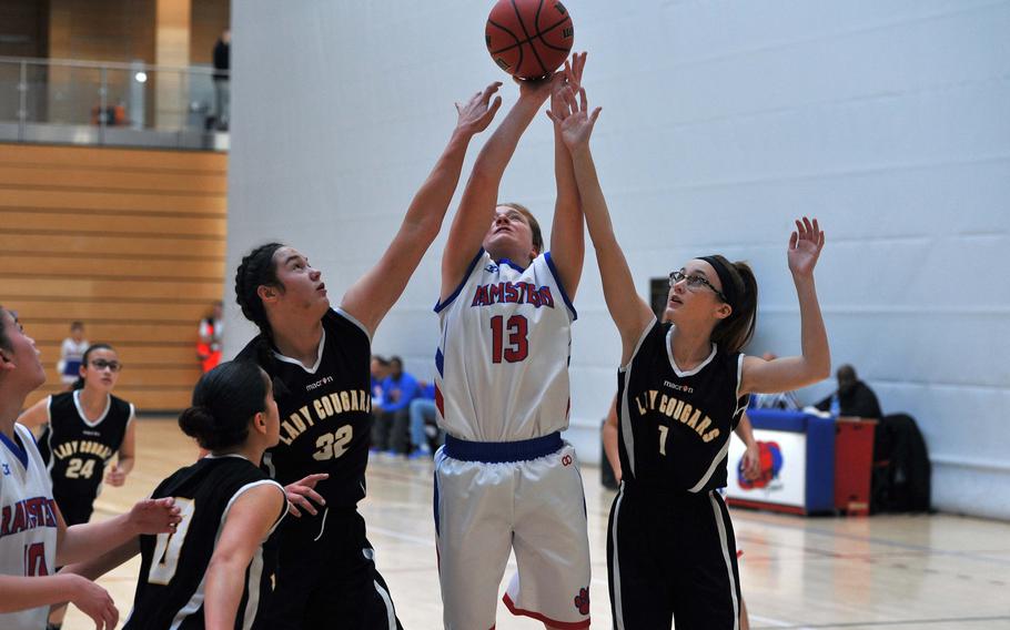 Ramstein's Alexis Tri shoots against the Vicenza defense of Brealin Redecker, left, and Emily Kearns in a Division I game at the DODEA-Europe basketball finals. The Royals won the game 51-3.