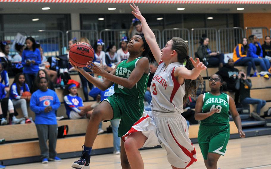 SHAPE's Maya Neal goes to the basket against Lakenheath's Catherine Oordt in a Division I game at the DODEA-Europe basketball finals. SHAPE won 42-31.