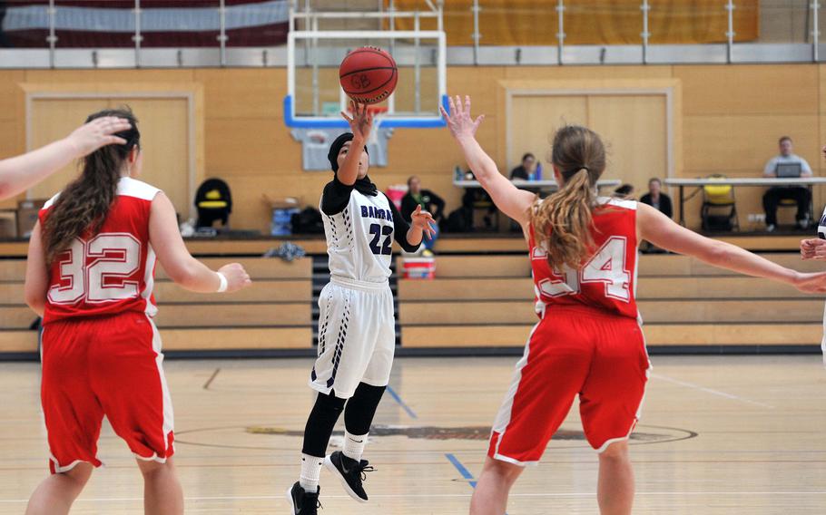 Bahrain's Tasneem Abdkhair scores on a jumper between AOSR's Sophie Joy Barber, left, and Evan Laura Park in a girls Division II semifinal at the DODEA-Europe basketball championships in Wiesbaden, Germany. AOSR won the game 35-27 to advance to Saturday's final against AFNORTH.