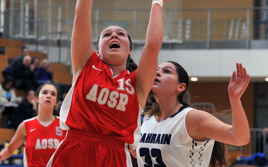 AOSR's Isabela Walsh gets past Bahrain's Christina Carpenter in a girls Division II semifinal at the DODEA-Europe basketball championships in Wiesbaden, Germany. AOSR won the game 35-27 to advance to Saturday's final against AFNORTH.