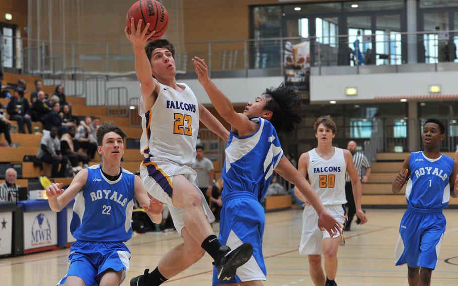 Bahrain's Derek Westerndorf goes to the basket against Marymount's Steven Ye in a Division II semifinal at the DODEA-Europe basketball championships in Wiesbaden, Germany. Watching the action are Francesco Gnecco, left, Peter Curling and Elton Muzime. The Falcons are in Saturday's final; after defeating the Royals 63-40.