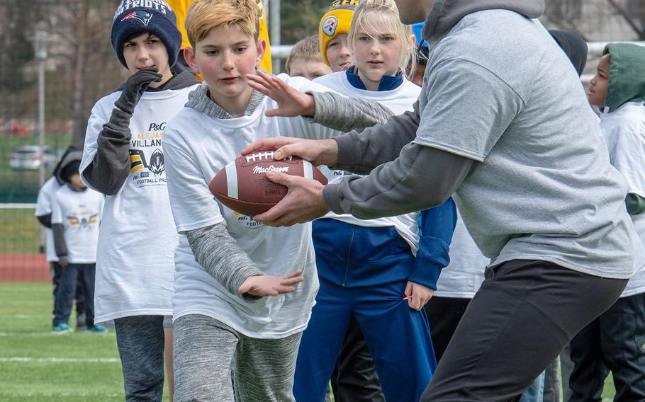 A pro camp participant takes a handoff during a drill at Kaiserslautern High School football field Saturday, April 13, 2019. More than 200 kids from around Germany attended the two-day football camp.