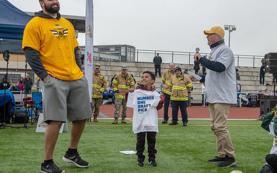 Pittsburg Steelers offensive lineman Alejandro Villanueva presents Khlil Mackey, 6, with the number one draft pick t-shirt before a pro camp at Kaiserslautern High School football field Saturday, April 13, 2019. More than 200 kids from around Germany attended the two-day football camp.