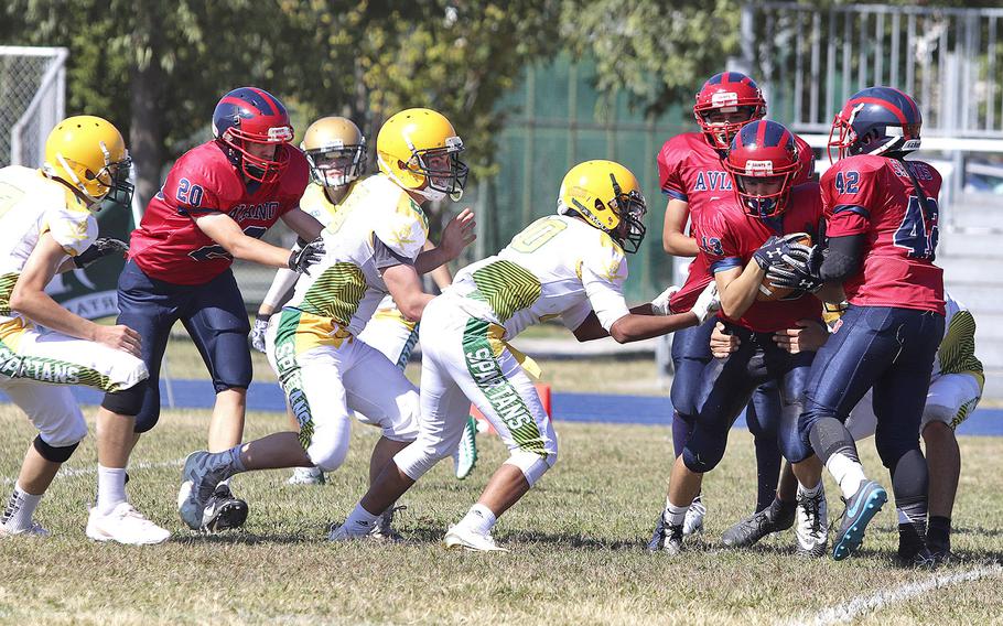 The SHAPE Spartans attempt to stop Aviano Saints wide receiver Jace Boren during the Saints' 52-16 victory over the Spartans on Saturday, Sept. 21, 2019.