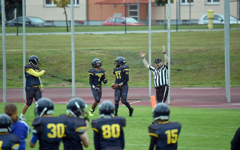 The referee puts his hands up as Cougar Devin Jenkins scores one of his several touchdowns in a game against Brussels, at Ansbach, Germany, Friday, Sept. 27, 2019. 