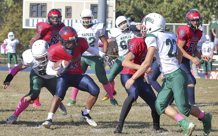Josiah Cooper, a running back with the Aviano Saints, attempts to run past Naples' defenders during Saturday's DODEA Division II game held at Aviano between the Saints and the Naples Wildcats. Aviano won the game 24-10 and will play host to the Rota Admirals, Nov. 2 in the championship game.