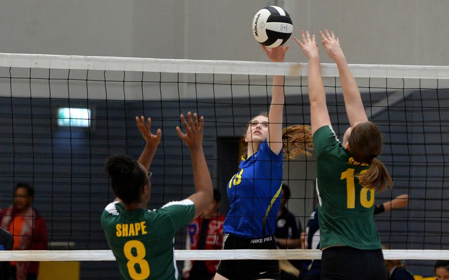 Wiesbaden's Kaleigh Mackey knocks the ball over the net against SHAPE's Camilla Menefee, left, and Hope Minor in a Division I match at the DODEA-Europe volleyball championships in Ramstein, Germany, Oct. 31, 2019. Wiesbaden won 25-12, 25-15, 15-7.