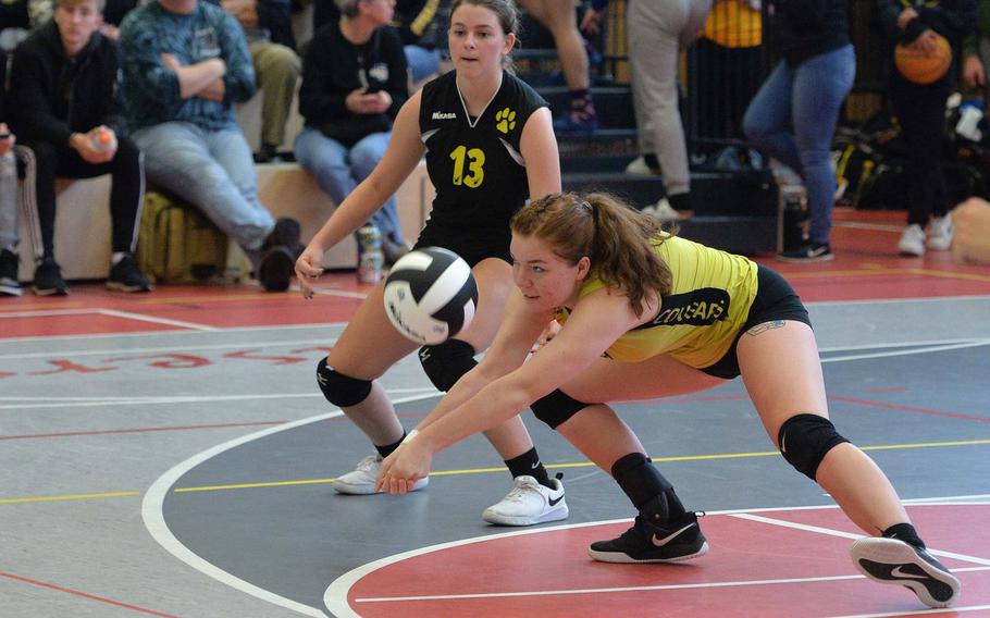 Vicenza libero Ella Dupree digs out a Naples serve as teammate Madeline Mollner watches in the Division II finals at the DODEA-Europe volleyball championships in Kaiserslautern, Germany, Saturday, Nov. 2, 2019. Vicenza took the title with a 17-25, 25-17,25-19, 25-17 win.