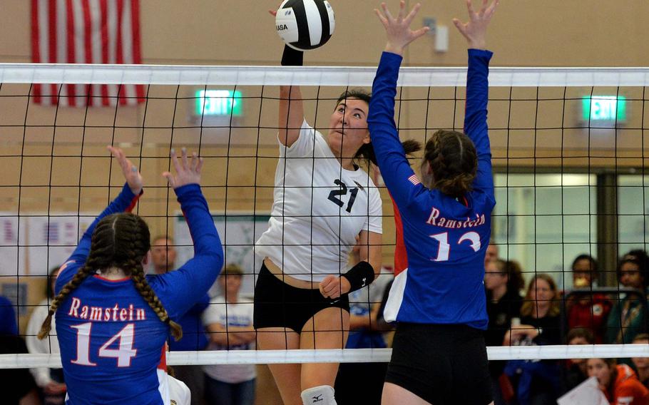 Stuttgart's Karen Kosinski slams the ball past the Ramstein defense of Lauren Szczygeil, left, and Sequoia Juhaz in the Division I final at the DODEA-Europe volleyball championships in Kaiserslautern, Saturday, Nov. 2, 2019. Ramstein beat Stuttgart 21-25, 25-21, 22-25, 25-23, 20-18.